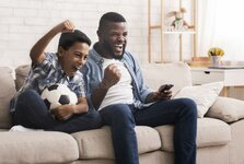 black-father-son-soccer-fans-watching-football-tv-afro-home-emotionaly-cheering-sitting-ball-c...jpg